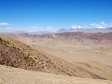 18 Pass North Of Drolung Tso Lake With View Ahead Toward Saga With 6000m Mountains Northeast Of Saga The road climbs from Drolung Tso Lake to a pass on the way to Saga with the 6000m mountains northeast of Saga visible in the distance.